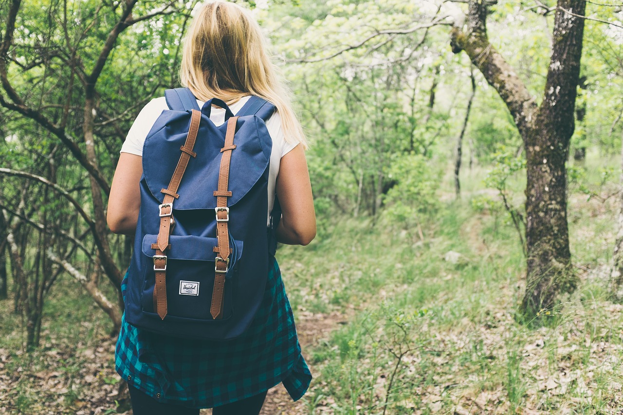 woman in the woods wearing a backpack